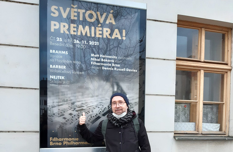 Michal Nejtek u plakátu na koncert Filharmonie Brno (zdroj Filharmonie Brno)