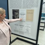 Hudební historička PhDr. Lenka Černíková, Ph.D. u plakátu prvního festivalového koncertu (zdroj Mezinárodní hudební festival Leoše Janáčka)